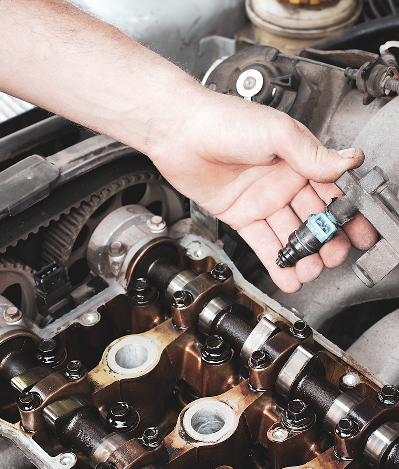 Mechanic fixing fuel injector, two camshaft car engine